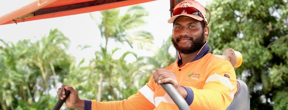 Bama employeee wearing orange high vis uniform and hat smiling to camera