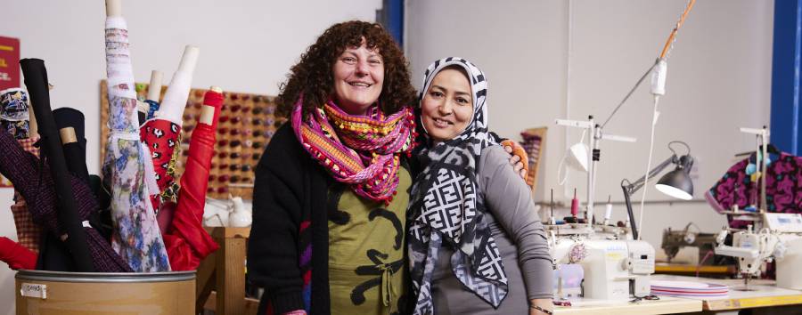 Two women smiling from social enterprise the social outfit